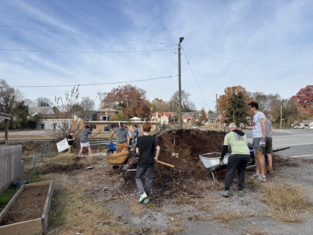 Volunteers participate in a community garden project, digging and preparing soil for planting, promoting local food growth and community bonding in Knox County.