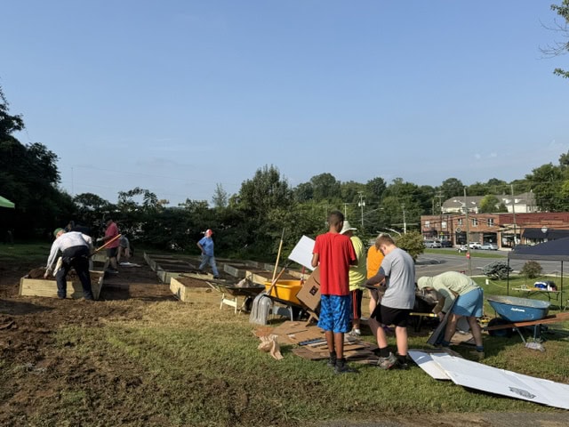 Community members and volunteers working together to build a new community garden in Knox County, promoting local food security and sustainable agriculture.