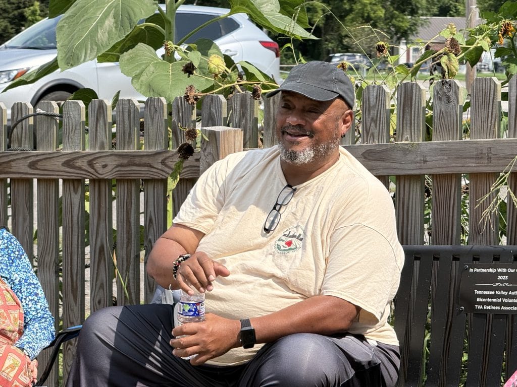 Smiling man at Knox County Community Garden & Growers Alliance event holding a water bottle.